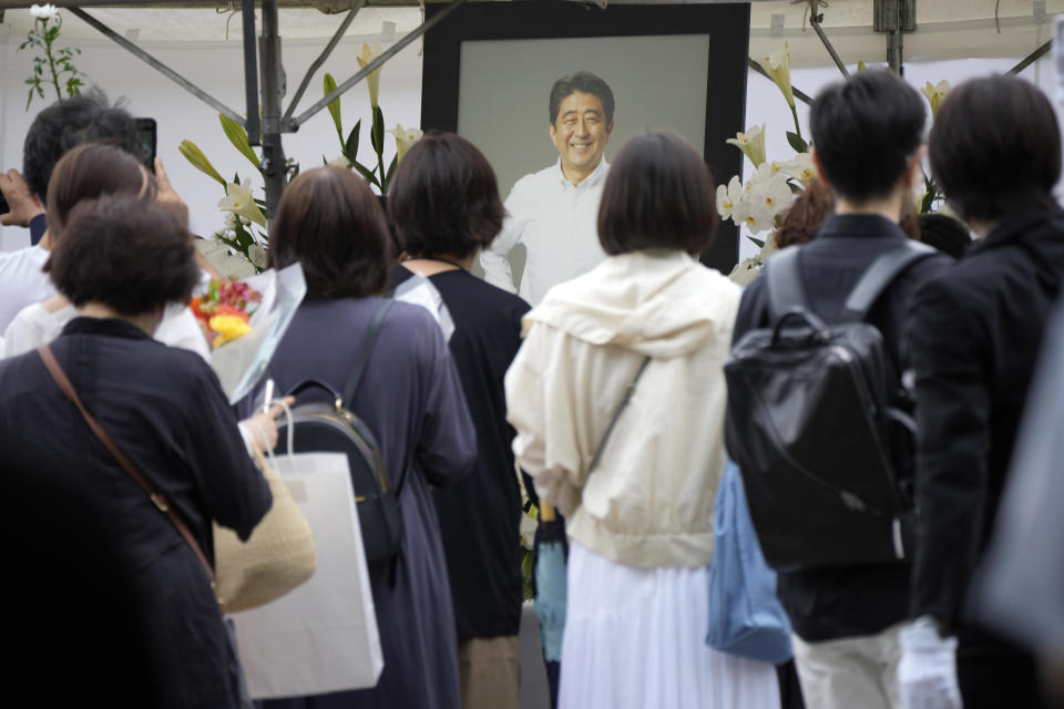 People line up to offer flowers and prayers for former Prime Minister Shinzo Abe, at the Zojoji Buddhist temple prior to his funeral on July 12, 2022, in Tokyo, Japan. / Credit: Eugene Hoshiko/AP