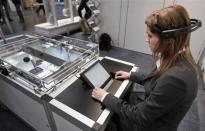 A woman poses with a brain-computer interface (BCI), a solution for future human-machine cooperation, at the Festo stand during a guided press tour at the "Hannover Messe" industrial trade fair in Hanover April 22, 2012.