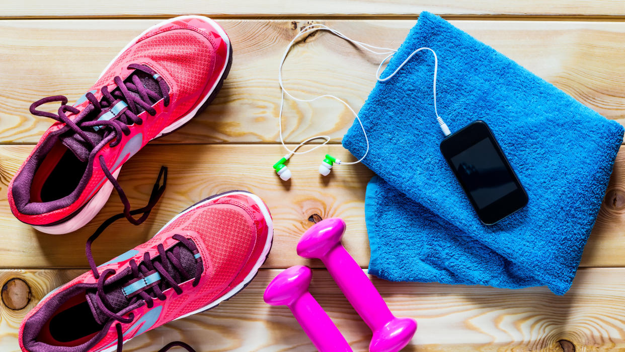 Women's running shoes and dumbbells for training.