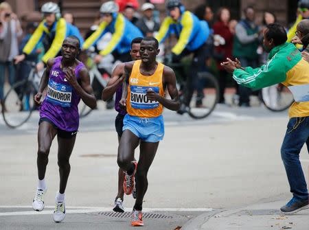 Geoffrey Kamworor of Kenya (L) and Stanley Biwott of Kenya recieve some encouragement during the New York Cirty Marathon in New York November 1, 2015. REUTERS/Carlo Allegri