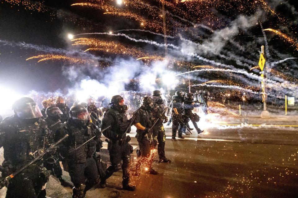 Police use chemical irritants and crowd control munitions to disperse protesters during a demonstration in Portland, Ore., Saturday, Sept. 5, 2020. Hundreds of people gathered for rallies and marches against police violence and racial injustice Saturday night in Portland, Oregon, as often violent nightly demonstrations that have happened for 100 days since George Floyd was killed showed no signs of ceasing. (AP Photo/Noah Berger)