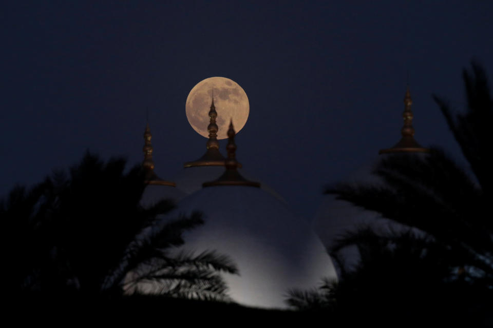 <p>A lunar eclipse of a full “Blood Moon” rises behind the Sheikh Zayed Grand Mosque in Abu Dhabi, United Arab Emirates, July 27, 2018. (Photo: Christopher Pike/Reuters) </p>