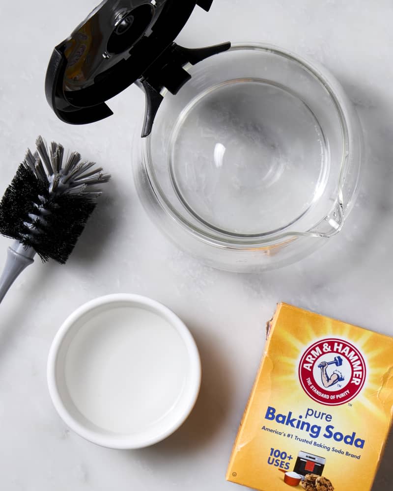 A coffee pot with baking soda and water on a marble surface