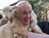 And it's not just kids. A woman (unseen), dressed as a character from the nativity scene, put a lamb around the neck of Pope Francis as he arrived to visit the Church of St Alfonso Maria dei Liguori in the outskirts of Rome January 6, 2014. REUTERS/Osservatore Romano