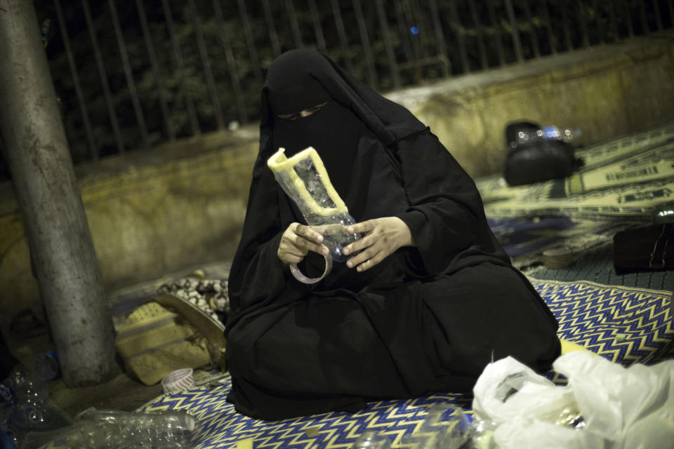 A woman supporter of Egypt's ousted President Mohammed Morsi makes a home made gas mask during a protest near Cairo University in Giza, Egypt, Thursday, August, 1, 2013. (AP Photo/Manu Brabo)