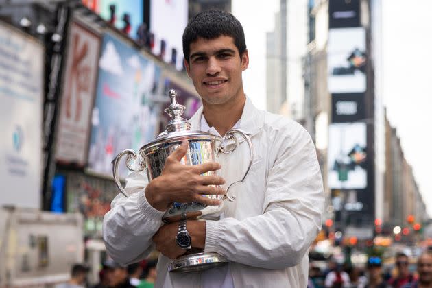 El campeón del US Open,Carlos Alcaraz, posa con el trofeo en Times Square. (Photo: via Associated Press)