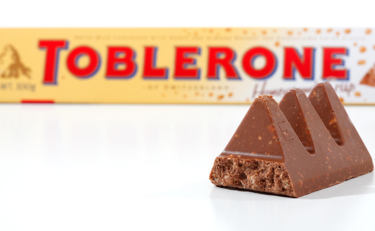 "Penrith, Australia - February 25, 2011:  100g Toblerone chocolate bar (2155kj) containing honey and almond nougat, cristpy rice and chocolate, made in Switzerland for Kraft Foods.  Packaging at rear with pieces of the chocolate bar in focus in the foreground.  Photographed in studio on white background."