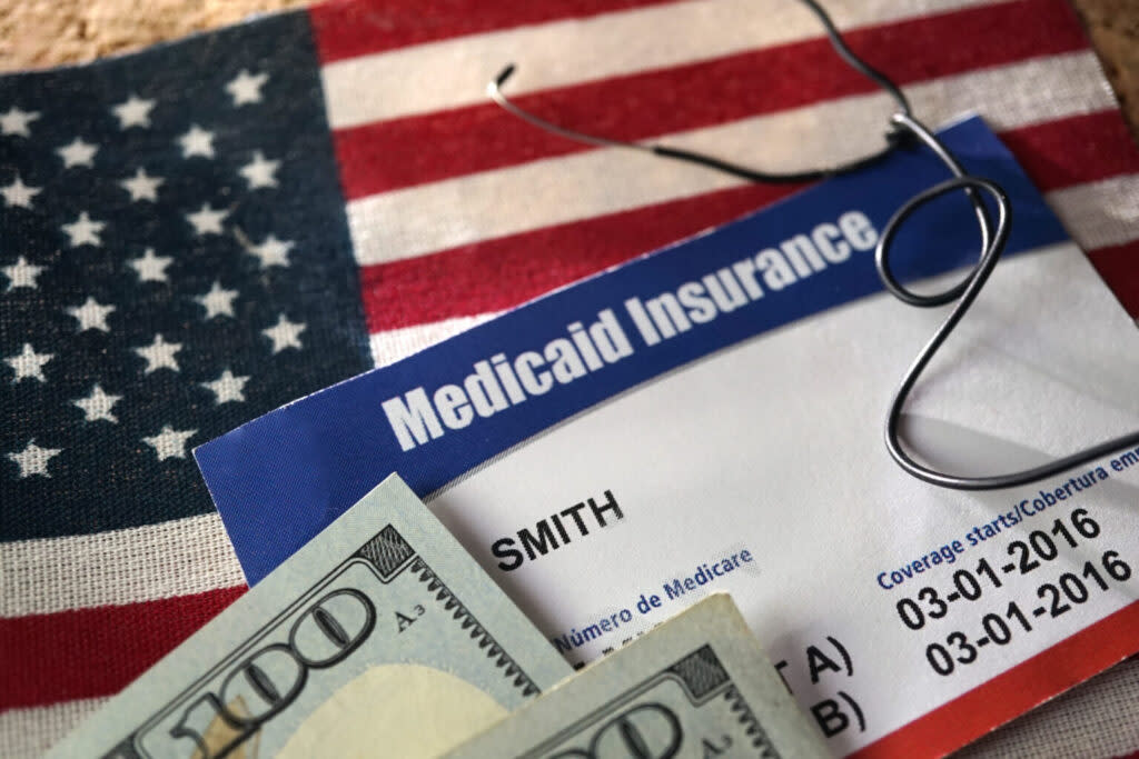 Medical theme photo with health insurance, money American flag, Medicaid card