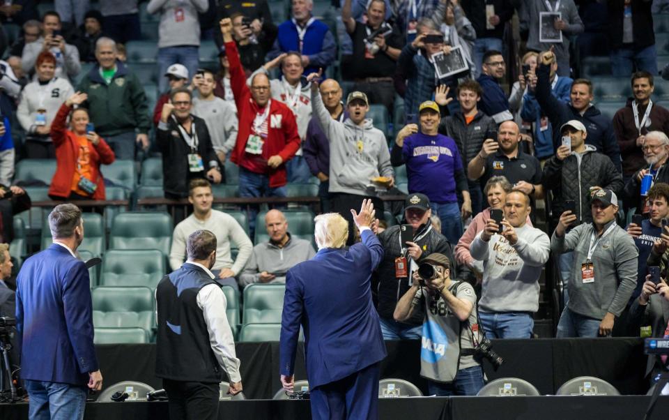 Donald Trump waves to the crowd during a wrestling tournament - Brett Rojo