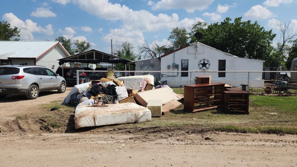 Damaged furniture and goods are laid outside of flooded homes Tuesday in El Campo neighborhood of Hereford,