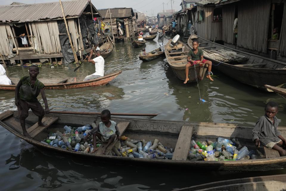 FILE - Children sit inside a canoe with empty plastic bottles they collected to sell for recycling in the floating slum of Makoko in Lagos, Nigeria, Nov. 8, 2022. Reducing waste while boosting recycling and reuse, known as the ‘circular economy,’ will be vital for halting the loss of nature, organizers of the World Circular Economy Forum said Wednesday, Dec. 7. (AP Photo/Sunday Alamba, File)