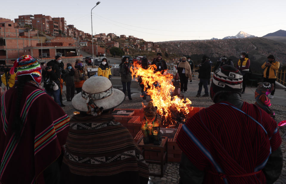 Los líderes espirituales andinos con máscaras faciales en medio de la propagación del nuevo coronavirus realizan un ritual de año nuevo en el Mirador Jach'a Apacheta de Munaypata, en La Paz, Bolivia, el domingo 21 de junio de 2020. Las comunidades indígenas aymaras celebran el Año Nuevo Andino 5.528. (Foto AP/Juan Karita)