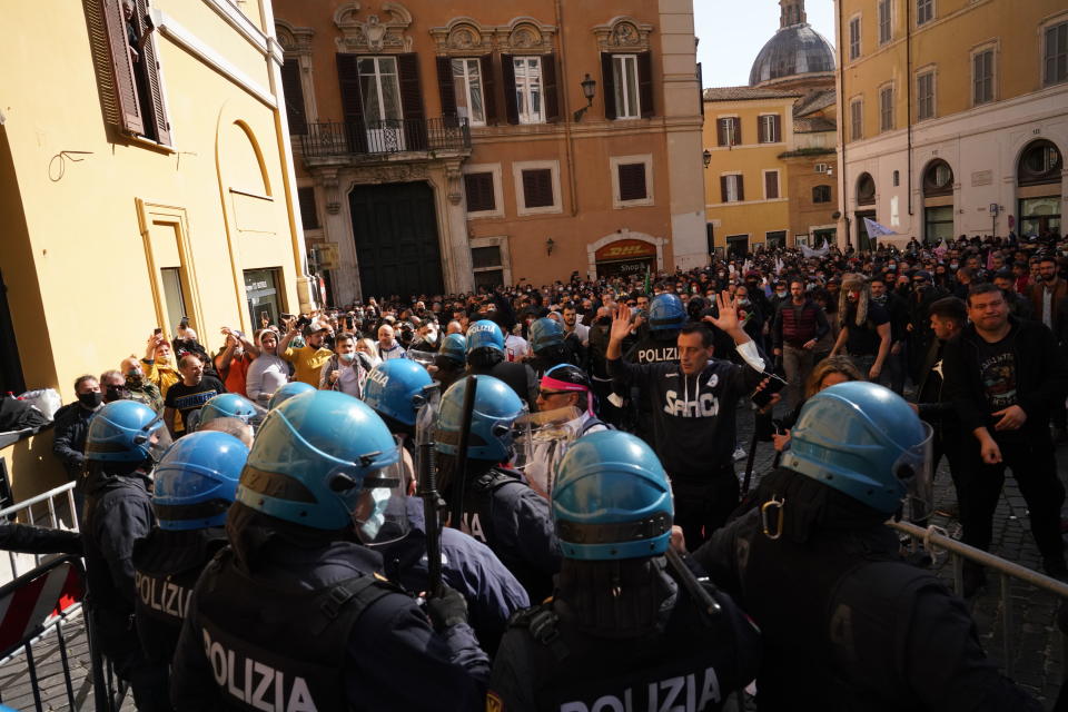 Demonstrators scuffle with Italian Policemen during a protest by Restaurant and shop owners outside the Lower Chamber in Rome, Tuesday, April 6, 2021. Demonstrators demanded to reopen their business and protested against restrictive measures by the Italian Government to cope with the surge of COVID-19 cases. (AP Photo/Andrew Medichini)