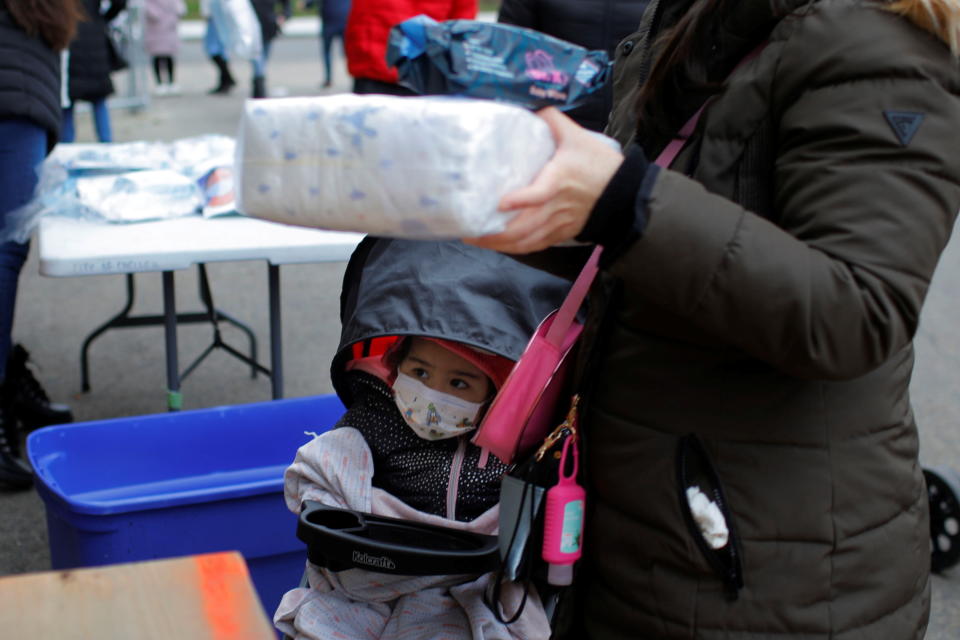 Two-year-old Estefania Chacon watches as her mother picks up free diapers provided by the Chelsea Collaborative, amid the coronavirus disease (COVID-19) outbreak, in Chelsea, Massachusetts, U.S., November 25, 2020.   REUTERS/Brian Snyder