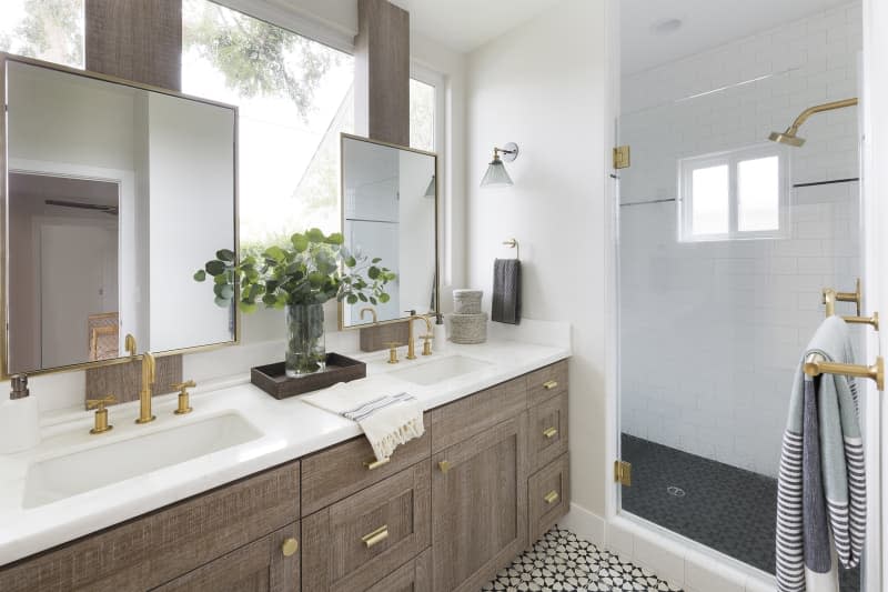 Large bathroom vanities and a shower designed in earth tones