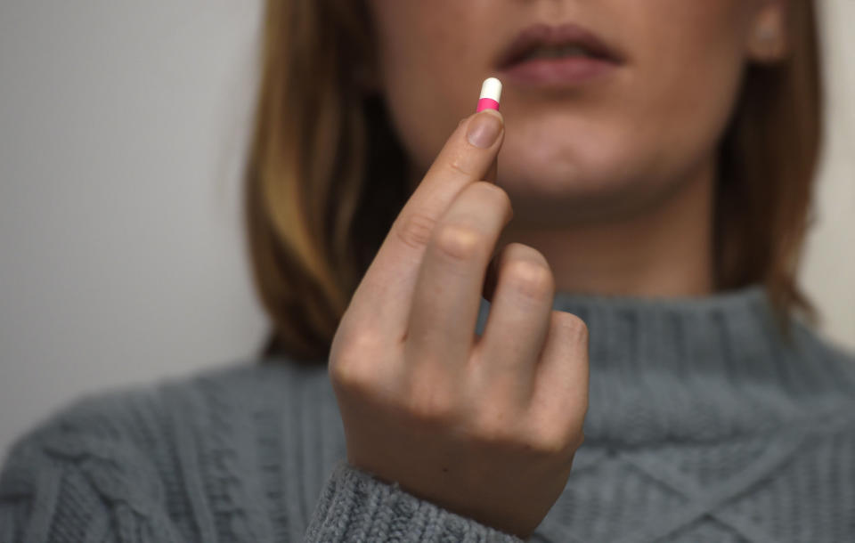 A woman holding an Ibuprofen tablet. Source: AAP