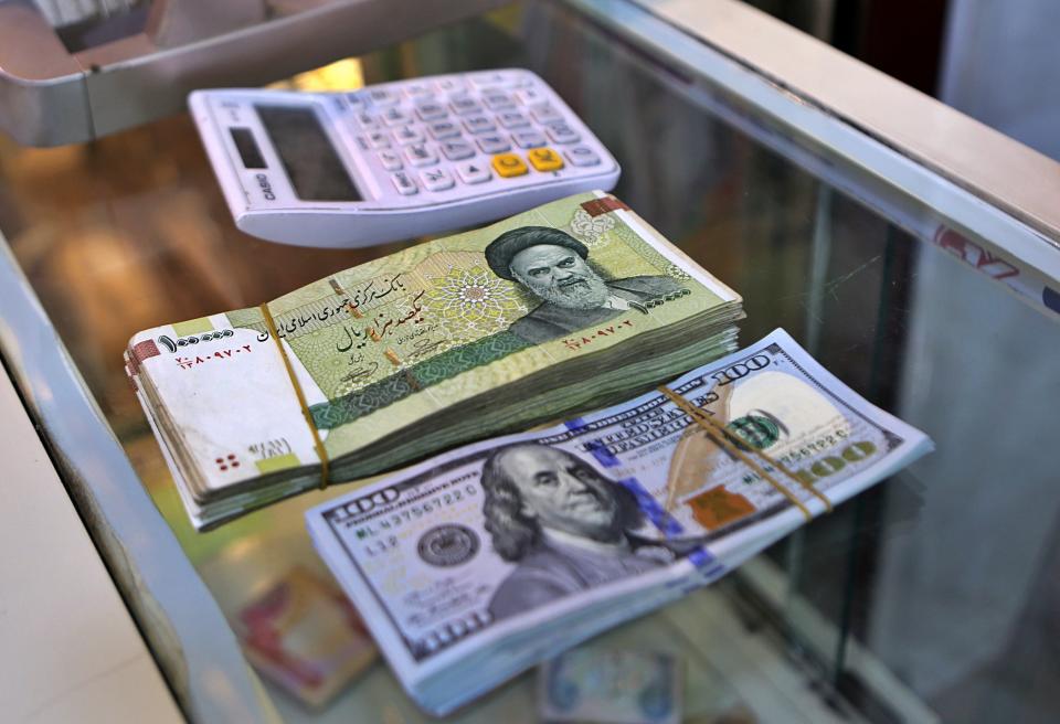 In this Wednesday, May 21, 2019, photo, U.S. and Iranian currency are readied by a money exchanger outside the golden-domed shrine of Imam Moussa al-Kadhim in Kadhimiya district in north Baghdad, Iraq. Many shop owners in Baghdad's northern Shiite holy neighborhood of Kadhimiya, have seen their sales drop sharply over the past year since U.S. President Donald began reimposing sanctions on Iran, home to the largest number of Shiite Muslims around the world. (AP Photo/Khalid Mohammed)