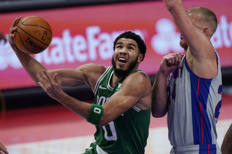 Boston Celtics forward Jayson Tatum (0) makes a layup as Detroit Pistons center Mason Plumlee defends during the first half of an NBA basketball game Friday, Jan. 1, 2021, in Detroit. (AP Photo/Carlos Osorio)