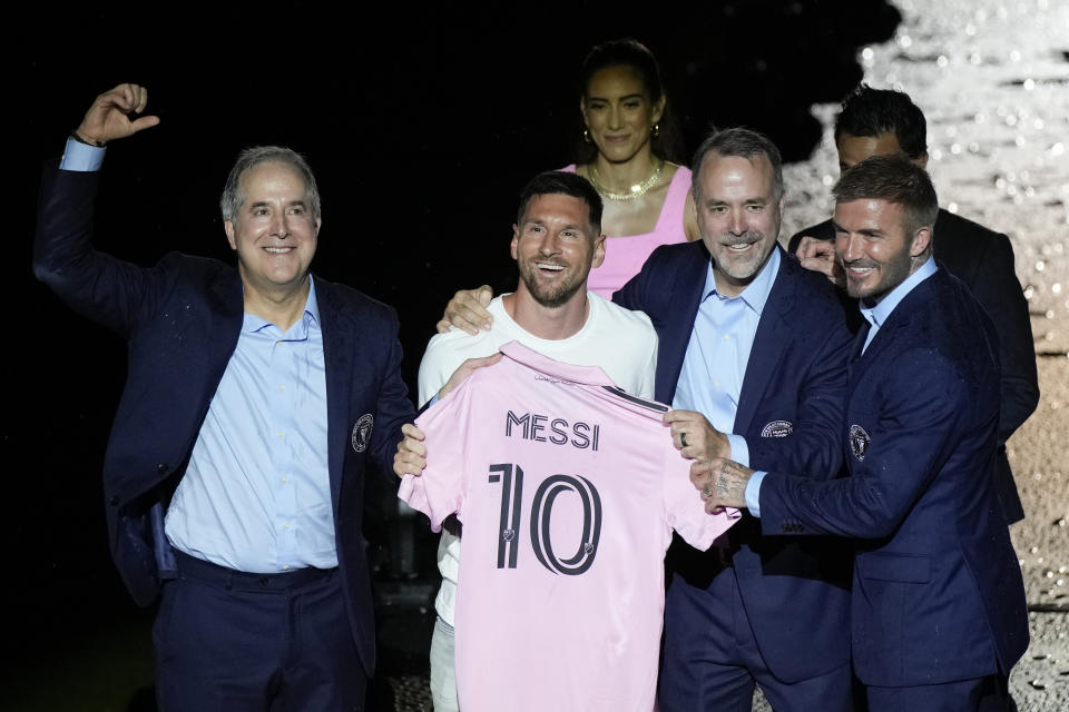 Lionel Messi holds his new Inter Miami team jersey as he poses with team co-owners Jorge Mas, left, Jose Mas, second right, and David Beckham, right, at an event to present him to fans on July 16. (AP)