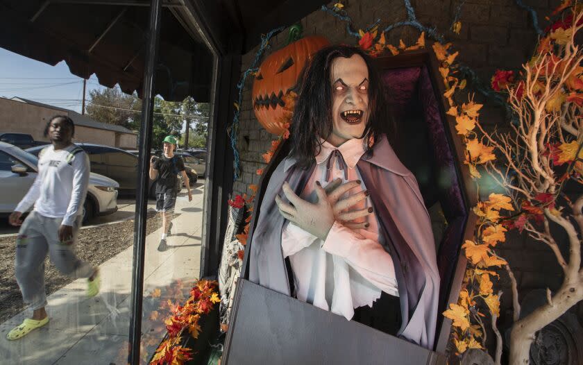 BURBANK, CA - October 10, 2022 - Customers walk past a window at the Halloween Town store Monday, Oct. 10, 2022 in Burbank, CA. (Brian van der Brug / Los Angeles Times)