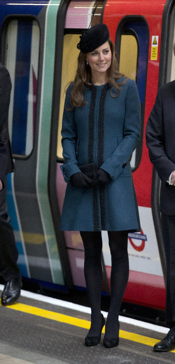 FILE - This March 20, 2013 file photo shows Kate, the Duchess of Cambridge, pregnant with her first child, watching as Queen Elizabeth II unveils a plaque at Baker Street underground station in London, during a visit to mark the 150th anniversary of the London Underground, The Duchess of Cambridge, Kate Middleton, possesses what might be the world's most famous baby bump, and she has made a seamless transition into her slightly revamped look. Fashion experts say streamlined style best suits a baby bump. (AP Photo/Matt Dunham, file)