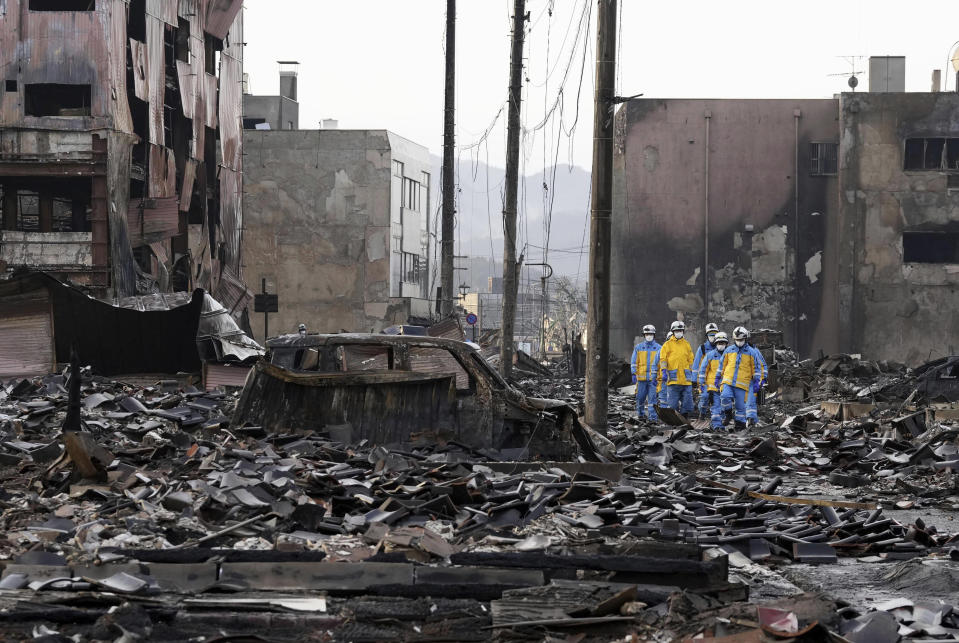 Police officers conduct a search operation around a burnt market in Wajima, Ishikawa prefecture, Japan Saturday, Jan. 6, 2024. A series of powerful quakes set off a large fire in the town of Wajima, as well as tsunamis and landslides in the region. (Kyodo News via AP)