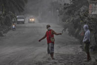 Residents walk along a road covered in volcanic ash from Taal volcano's eruption on January 13, 2020 in Lemery, Batangas province, Philippines. The Philippine Institute of of Volcanology and Seismology raised the alert level to four out of five, warning that a hazardous eruption could take place anytime, as Manila's international airport suspended flights and authorities began evacuating tens of thousands of people from the area. (Photo by Ezra Acayan/Getty Images)