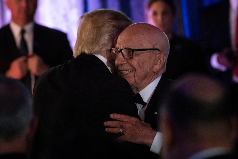 US President Donald Trump (L) is embraced by Rupert Murdoch, Executive Chairman of News Corp, during a dinner to commemorate the 75th anniversary of the Battle of the Coral Sea during WWII (AFP via Getty Images)