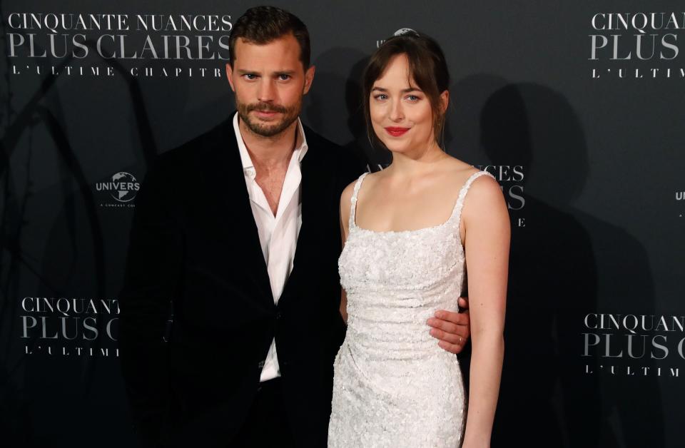 Actor Jamie Dornan (L) and actress Dakota Johnson pose as they arrive to attend 'Fifty Shades Freed - 50 Nuances Plus Claires' Premiere at Salle Pleyel in Paris on February 6, 2018.  / AFP PHOTO / PATRICK KOVARIK        (Photo credit should read PATRICK KOVARIK/AFP/Getty Images)