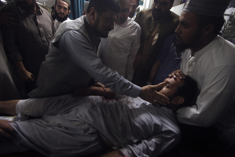 Relative of an injured victim of a powerful bomb stand around his bed at a hospital in Peshawar, Pakistan, Sunday, July 30, 2023. A bomb ripped through a rally by supporters of a hard-line cleric and political leader in the country's northwestern Bajur district that borders Afghanistan on Sunday, police and health officials said. (AP Photo/Muhammad Sajjad)