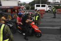 Police officers inspect motorists at a checkpoint during a stricter lockdown as a precaution against the spread of coronavirus on the outskirts of Marikina City, Philippines on Friday, August 6, 2021. Thousands of people jammed coronavirus vaccination centers in the Philippine capital, defying social distancing restrictions, after false news spread that unvaccinated residents would be deprived of cash aid or barred from leaving home during a two-week lockdown that started Friday. (AP Photo/Basilio Sepe)