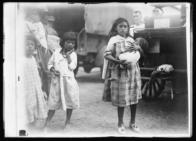 A young woman who survived the flood holds a baby after the disaster that killed dozens in her community. (Photo: Library of Congress)