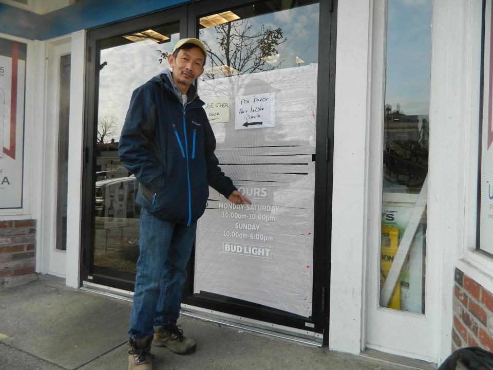 Rex Liquors store owner Ratana Hoan shows where his store was vandalized early Sunday morning on Broadway in Newport.