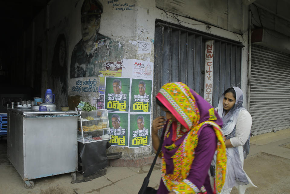 Sri Lankan Muslim women walks past posters of Sri Lanka's sacked prime minister Ranil Wickeremsinghe in Colombo, Sri Lanka, Wednesday, Oct. 31, 2018. Posters read in Sinhalese "our prime minister, country's prime minister, Ranil". President Maithripala Sirisena dismissed Wickremesinghe and his Cabinet on Friday and replaced him with former strongman Mahinda Rajapaksa. (AP Photo/Eranga Jayawardena)