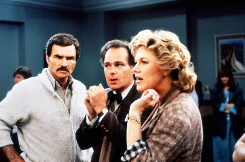 Burt Reynolds looks at Kathleen Turner who's standing next to another man in a scene from "Switching Channels"