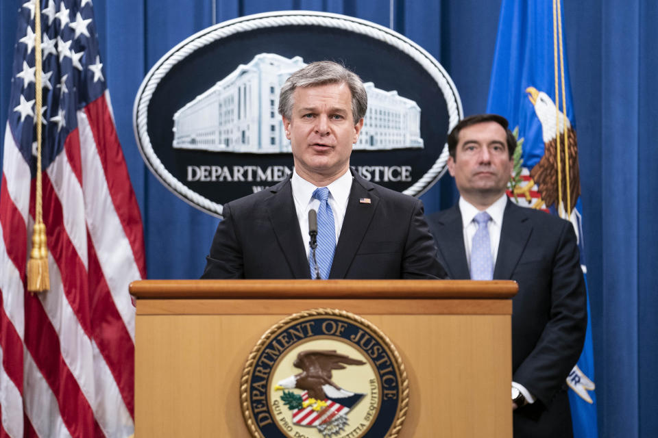 FBI Director Christopher Wray speaks during a virtual news conference at the Department of Justice, Wednesday, Oct. 28, 2020 in Washington, as Assistant Attorney General for National Security John Demers looks on. The Justice Department has charged eight people with working on behalf of the Chinese government to locate Chinese dissidents and political opponents living in the U.S. and coerce them into returning to China. Five of the eight were arrested Wednesday morning. (Sarah Silbiger/Pool via AP)