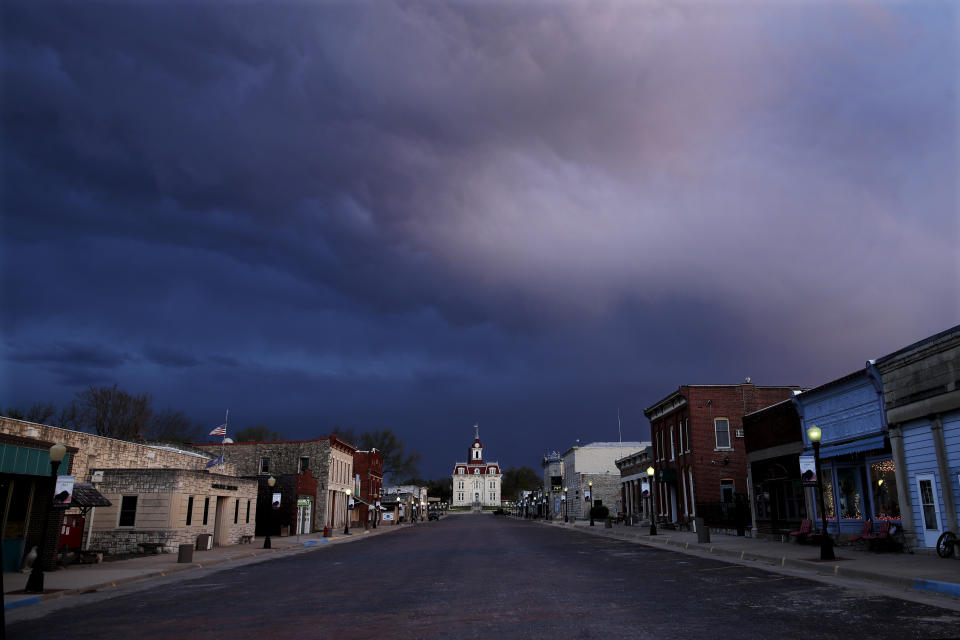 FILE - In this April 23, 202, file photo, a deserted street leads to the historic Chase County Courthouse at dusk in Cottonwood Falls, Kan. (AP Photo/Charlie Riedel, File)