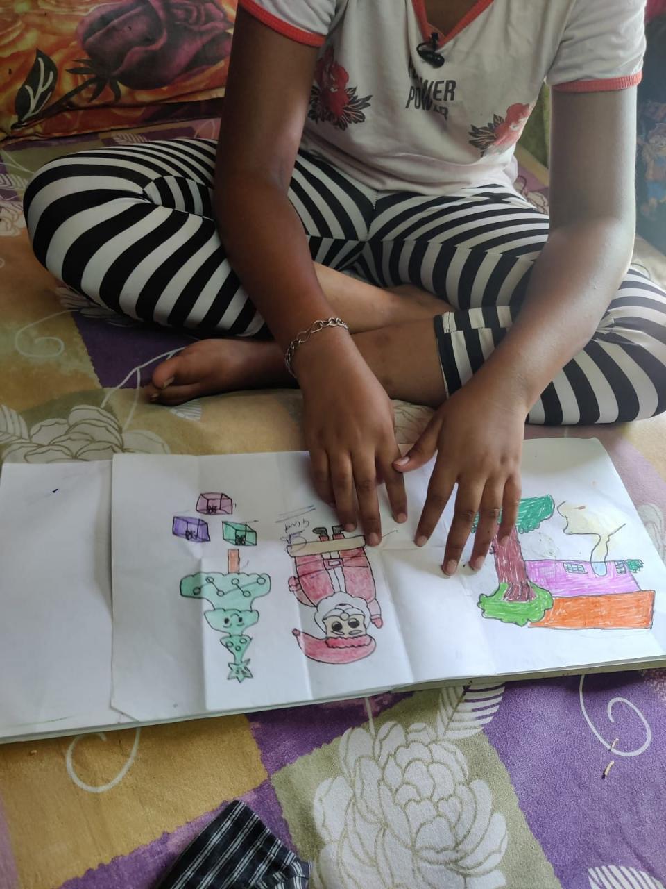 <div class="paragraphs"><p>Chhoti Nirbhaya showing her drawings.</p></div>