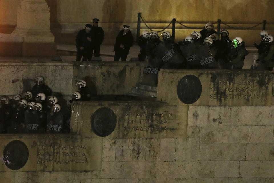 Riot police officers stand guard at the parliament next of the opponents of Prespa Agreement as they gathering at the Tomb of the Unknown Soldier during a rally in Athens, Thursday, Jan. 24, 2019. Greek lawmakers are debating a historic agreement aimed at normalizing relations with Macedonia in a stormy parliamentary session scheduled to culminate in Friday vote. (AP Photo/Petros Giannakouris)