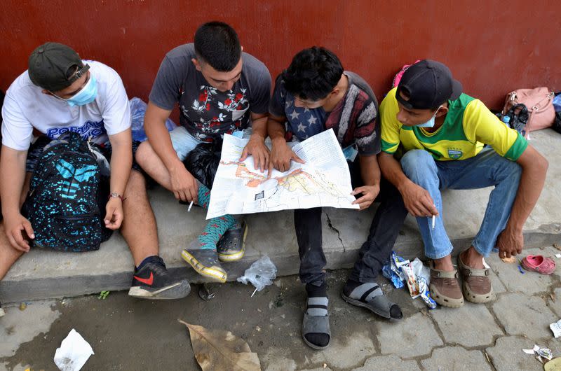 FILE PHOTO: A group of Honduran migrants who are trying to reach the U.S. , look at a Central America and Mexico map outside a migrant shelter as they wait to move towards the Guatemala and Mexico border, in Tecun Uman