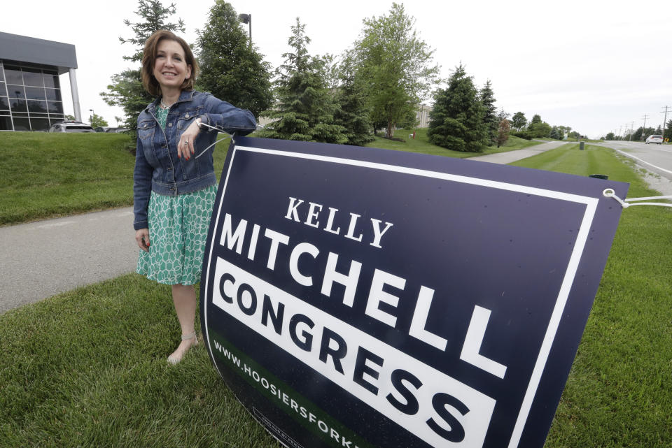 Indiana State Treasurer Kelly Mitchell stands by a campaign sign, Thursday, May 28, 2020, in Westfield, Ind. Mitchell is a candidate for Indiana's 5th Congressional District. More Republican women than ever are seeking House seats this year after the 2018 election further diminished their limited ranks in Congress. But so far it appears that any gains this November could be modest. (AP Photo/Darron Cummings)