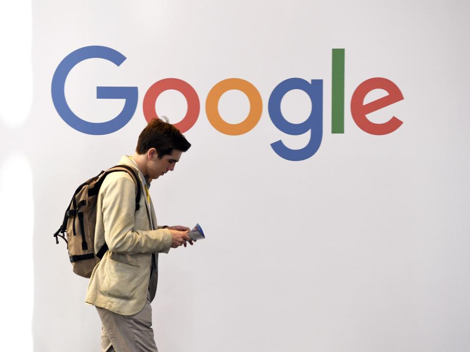 Man walking by Google logo