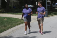 College students Alyssa Winters, left, and Ben Kennedy, right, chat as they go door-to-door to talk to prospective voters about a proposed amendment to the Kansas Constitution that would allow legislators to further restrict or ban abortion, Friday, July 8, 2022, in Olathe, Kansas. They are among about 300 college students brought into Kansas by the Susan B. Anthony Pro-Life America group, which backs the measure. (AP Photo/John Hanna)