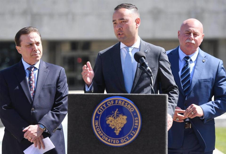 Fresno City Attorney Andrew Janz, center, with councilmember Garry Bredefeld to the left, and Mayor Jerry Dyer, to the right, answers a question from the media about a proposed ordinance to go before the city council which would fine those who attend and watch as well as participate in any street racing, sideshow or other driving they called reckless, during a press conference in front of Fresno City Hall Wednesday, April 19, 2023 in Fresno. .