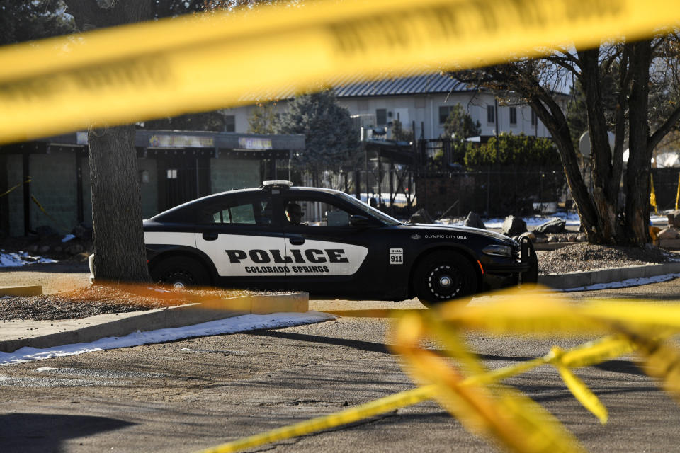 A Colorado Springs police car behind yellow police tape.