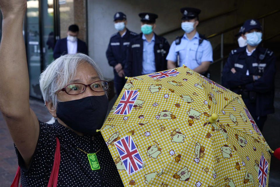 Pro-democracy activist Alexandra Wong holding yellow umbrella with British flags protests outside the Chinese central government's liaison office, in Hong Kong, Monday, Dec. 28, 2020, to demand the release of the 12 Hong Kong activists detained at sea by Chinese authorities. (AP Photo/Kin Cheung)