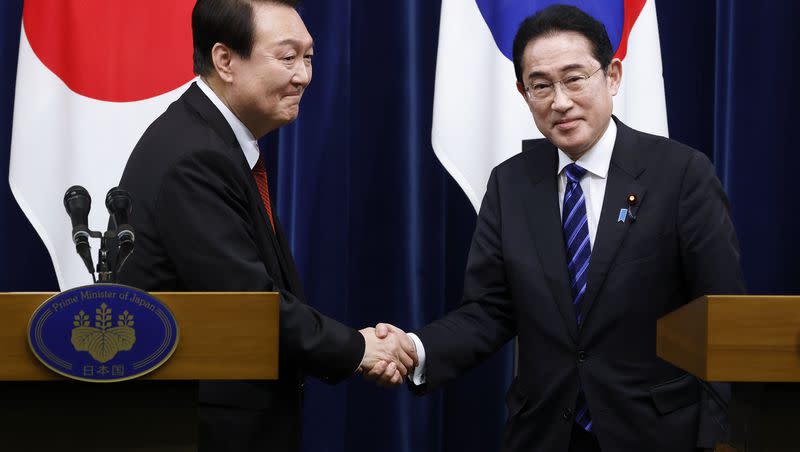 South Korean President Yoon Suk Yeol, left, and Japanese Prime Minister Fumio Kishida, right, shake hands following a joint news conference at the prime minister’s official residence in Tokyo, Japan, Thursday, March 16, 2023.