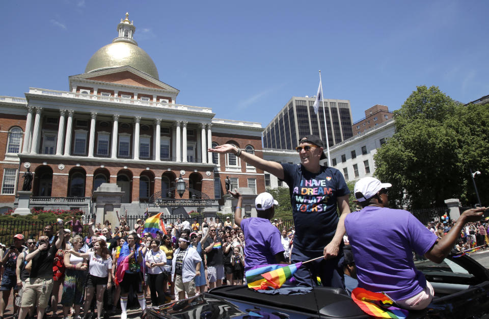 In this June 8, 2019, photo, Boston Pride Parade grand marshal Dale Mitchell waves as he rides in a convertible past the Statehouse during the Gay Pride Parade in Boston. Mitchell was at The Stonewall Inn when riots broke out between gays and police 50 years earlier in New York's Greenwich Village. (AP Photo/Elise Amendola)