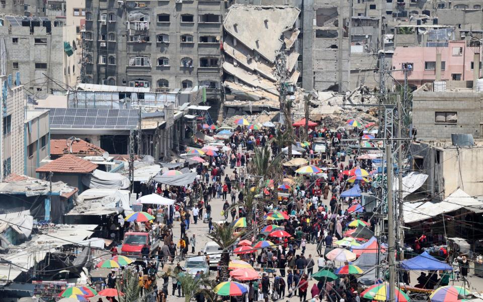 Palestinians living in Jabalia refugee camp, north of Gaza City, do their daily shopping in the market set up between buildings destroyed in the Israeli attacks