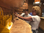 In this July 27, 2018 photo, Cindy Paul, 55, and her daughter, Doc Paul, 31, both of Billings, Montana, shop for marijuana edibles at a marijuana retail store in downtown Portland, Ore. Cindy Paul has not used marijuana in 25 years but is trying it again now that it's legal in Oregon. Paul, a client manager at an insurance firm, says the "stoner" stereotype that once surrounded marijuana users is no longer relevant and she considers using the drug similar to having a beer to relax. (AP Photo/Gillian Flaccus)